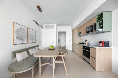 a living room with a table and a kitchen at 2916 Heart of Downtown Apt with Gym a Pool and a Coworking Space in Miami