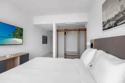 a white bedroom with a bed and a sliding glass door at 2916 Heart of Downtown Apt with Gym a Pool and a Coworking Space in Miami