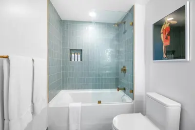 a white bathroom with a tub and a toilet at 2916 Heart of Downtown Apt with Gym a Pool and a Coworking Space in Miami