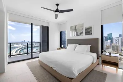 a bedroom with a white bed and large windows at 2916 Heart of Downtown Apt with Gym a Pool and a Coworking Space in Miami