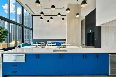 a kitchen with blue cabinets and blue tables and windows at Ocean Front Condo Near Cruise Port, Bayfront Park, plus Free Parking in Miami