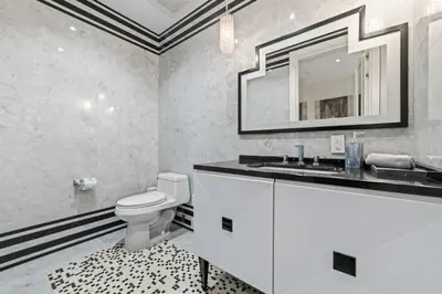 a bathroom with a toilet and a sink and a mirror at Luxury 5 Stars - Oceanfront Stay for 4 with World-Class Amenities in Miami Beach