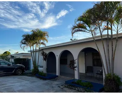 a car parked in front of a house with palm trees at Studios & Coral Gable, close to downtown and airport in Miami
