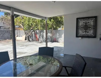 a glass table and chairs on a patio at Studios & Coral Gable, close to downtown and airport in Miami