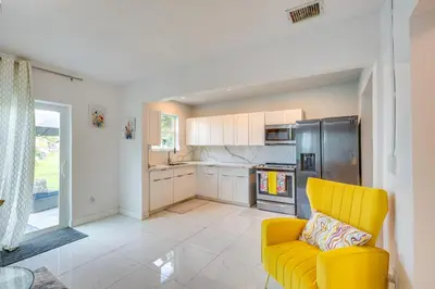 a kitchen with a yellow chair and a refrigerator at Walk to 2026 FIFA World Cup! Home with Spacious Yard in Miami