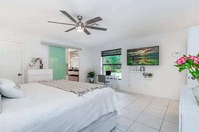 a white bedroom with a bed and a ceiling fan at Fox Island Heated Spa- Downtown & Beach in Fort Lauderdale