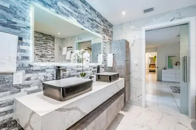 a bathroom with two sinks and a mirror at Fox Island Heated Spa- Downtown & Beach in Fort Lauderdale