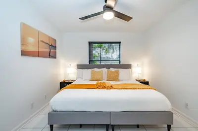a bedroom with a large bed with a ceiling fan at Fox Island Heated Spa- Downtown & Beach in Fort Lauderdale