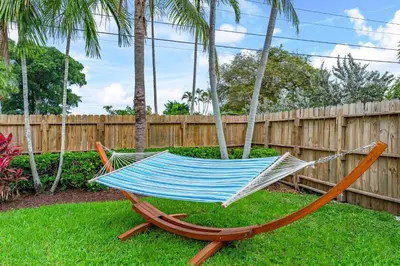 a hammock sitting in a yard next to a fence at Fox Island Heated Spa- Downtown & Beach in Fort Lauderdale