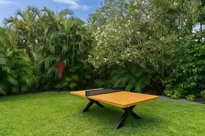 a wooden picnic table sitting in the grass at Fox Island Heated Spa- Downtown & Beach in Fort Lauderdale