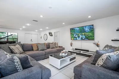 a living room with couches and a tv on the wall at Fox Island Heated Spa- Downtown & Beach in Fort Lauderdale