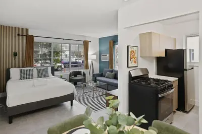 a living room with a bed and a kitchen with a stove at Harding Apartments by Andes STR in Miami Beach