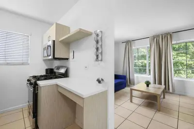 a kitchen with a white counter top and a table at Harding Apartments by Andes STR in Miami Beach