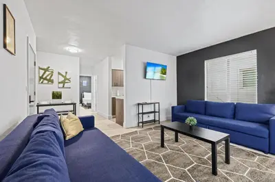 a living room with a blue couch and a table at Harding Apartments by Andes STR in Miami Beach