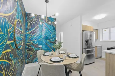 a dining room with a table and a refrigerator at Harding Apartments by Andes STR in Miami Beach
