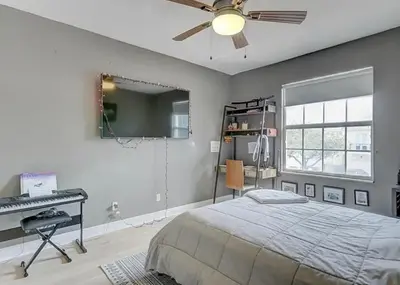 a bedroom with a bed and a desk and a ceiling fan at Family house with Heated Pool, Walk to Dining in Fort Lauderdale