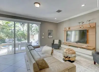 a living room with a couch and a flat screen tv at Family house with Heated Pool, Walk to Dining in Fort Lauderdale