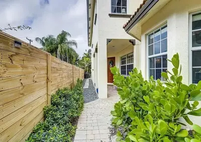 a wooden fence in front of a house at Family house with Heated Pool, Walk to Dining in Fort Lauderdale