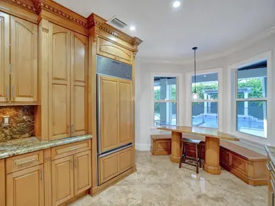 a kitchen with wooden cabinets and a wooden table at Casa Fina Miami Near Beaches