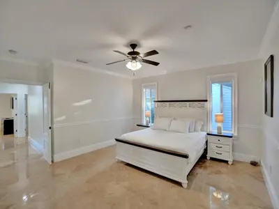 a white bedroom with a bed and a ceiling fan at Casa Fina Miami Near Beaches
