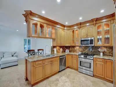 a kitchen with wooden cabinets and stainless steel appliances at Casa Fina Miami Near Beaches