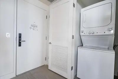 a kitchen with a washer and dryer next to a door at Miami Escape 16th Floor – Near Hollywood Beach in Hollywood