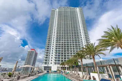 a large white building with a pool and palm trees at Miami Escape 16th Floor – Near Hollywood Beach in Hollywood