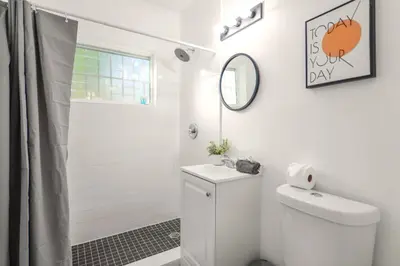 a white bathroom with a toilet and a shower at Coastal Studio Stay Near the Beach in Miami