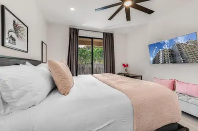 a bedroom with a white bed with a ceiling fan at Fox Sonata Downtown Pool House in Fort Lauderdale