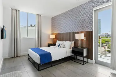 a bedroom with a bed and a large window at South Beach Sleek 2BR Getaway in Miami Beach