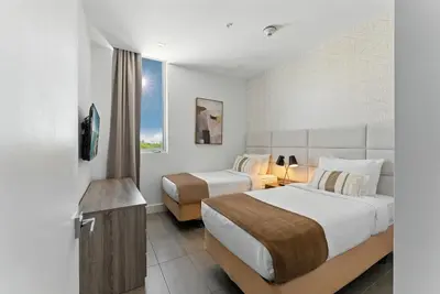 a hotel room with two beds and a television at SoBe 2 Bedroom Near Ocean Drive in Miami Beach