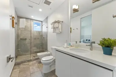 a bathroom with a toilet and a sink and a shower at South Beach Stylish 2BR Retreat in Miami Beach