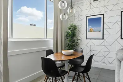 a dining room with a wooden table and black chairs at South Beach Stylish 2BR Retreat in Miami Beach