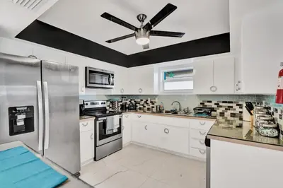 a kitchen with white cabinets and a ceiling fan at Trendy 4 Bedroom Pool Home Minutes from the Beach in Hollywood
