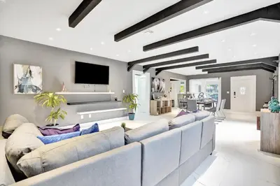 a living room with couches and a flat screen tv at Trendy 4 Bedroom Pool Home Minutes from the Beach in Hollywood