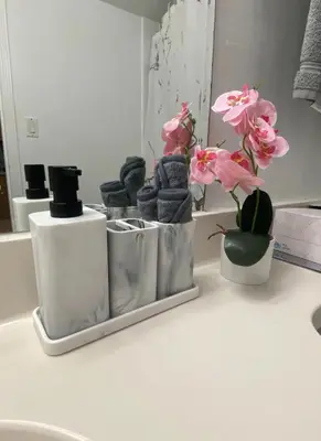 a bathroom counter with some towels and flowers on it at Pet Friendly Studio Beach and Pool Access, gym ! in Sunny Isles Beach