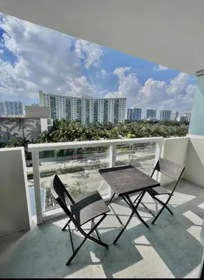 two chairs and a table on top of a balcony at Pet Friendly Studio Beach and Pool Access, gym ! in Sunny Isles Beach