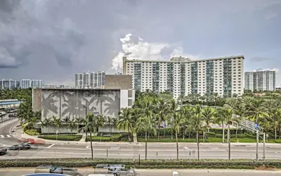 a large building with palm trees in front of a road at Pet Friendly Studio Beach and Pool Access, gym ! in Sunny Isles Beach