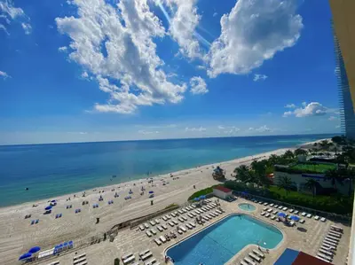 a view of the beach from the balcony of a resort at Pet Friendly Studio Beach and Pool Access, gym ! in Sunny Isles Beach