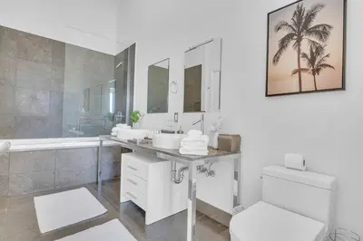 a bathroom with two sinks and a tub and a toilet at 40th floor High Ceilings unit at icon brickell in Miami