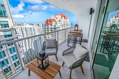 a balcony with two chairs and a table on a building at High Rise Unit in the heart of Brickell in Miami