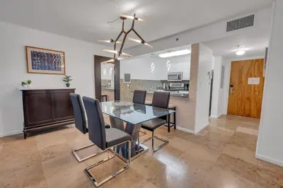 a dining room with a glass table and chairs at Amazing unit location with amenities & parking in Miami