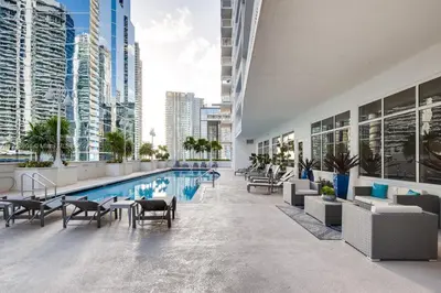 a pool in a building with chairs and tables at Luxurious 34th floor Ocean view Private Unit in Miami