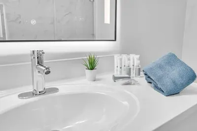 a white sink in a bathroom with a mirror at Luxurious 34th floor Ocean view Private Unit in Miami