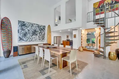 a dining room with a table and chairs and a staircase at Wonderful Tropical Pool House Miami Coconut Grove in Miami