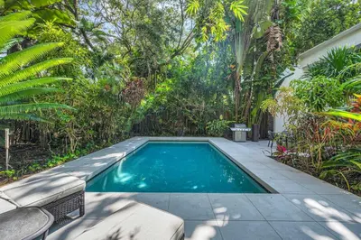a swimming pool in the middle of a garden at Wonderful Tropical Pool House Miami Coconut Grove in Miami
