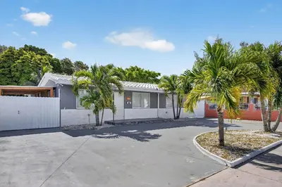 a house with palm trees in front of a driveway at Luxe 4BR Miami Pool-Near Airport-Games-Backyard in Miami