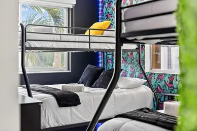 a bunk bed room with two beds and a couch at Luxe 4BR Miami Pool-Near Airport-Games-Backyard in Miami