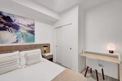 a white bedroom with a bed and a desk at Stylish Miami Condo with Beach Access at 72 Park in Miami Beach