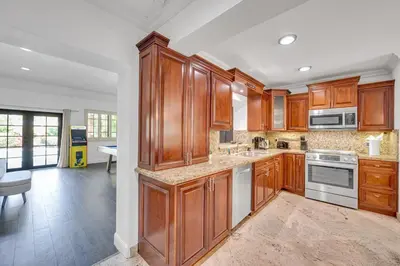 a large kitchen with wooden cabinets and appliances at Wonderful Tropical Pool House Miami South Brickell in Miami